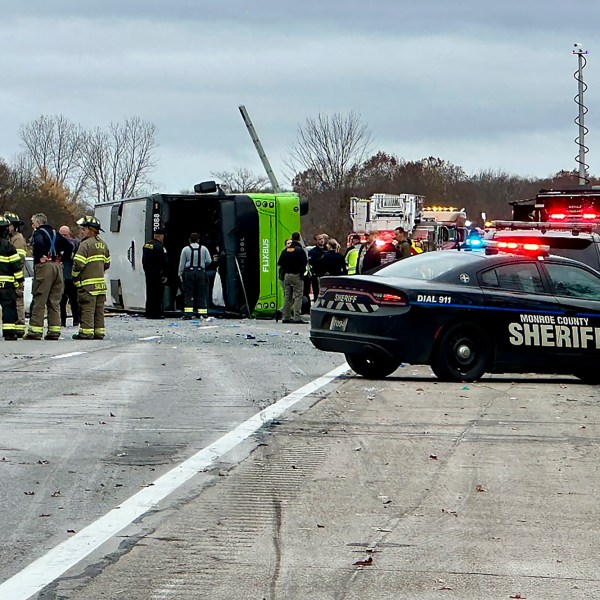 First responders investigate the scene where a tour bus rolled over on westbound Interstate 490 critically injuring one and sending all 28 passengers to area hospitals, Thursday, Nov. 7, 2024, in Chili, N.Y. (Monroe County Sheriff's Office via AP)