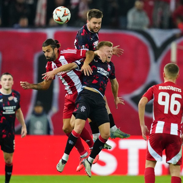 Olympiacos' Sergio Oliveira, left, jumps for the Baal among Rangers' Robin Proepper, centre and Connor Barron, right, during the Europa League opening phase soccer match between Olympiacos and Rangers at the Georgios Karaiskakis stadium at Athens' port of Piraeus, Greece, Thursday, Nov. 7, 2024. (AP Photo/Thanassis Stavrakis)