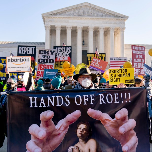 FILE - Stephen Parlato of Boulder, Colo., holds a sign that reads "Hands Off Roe!!!" as abortion rights advocates and anti-abortion protesters demonstrate in front of the U.S. Supreme Court, Wednesday, Dec. 1, 2021, in Washington. (AP Photo/Andrew Harnik, File)