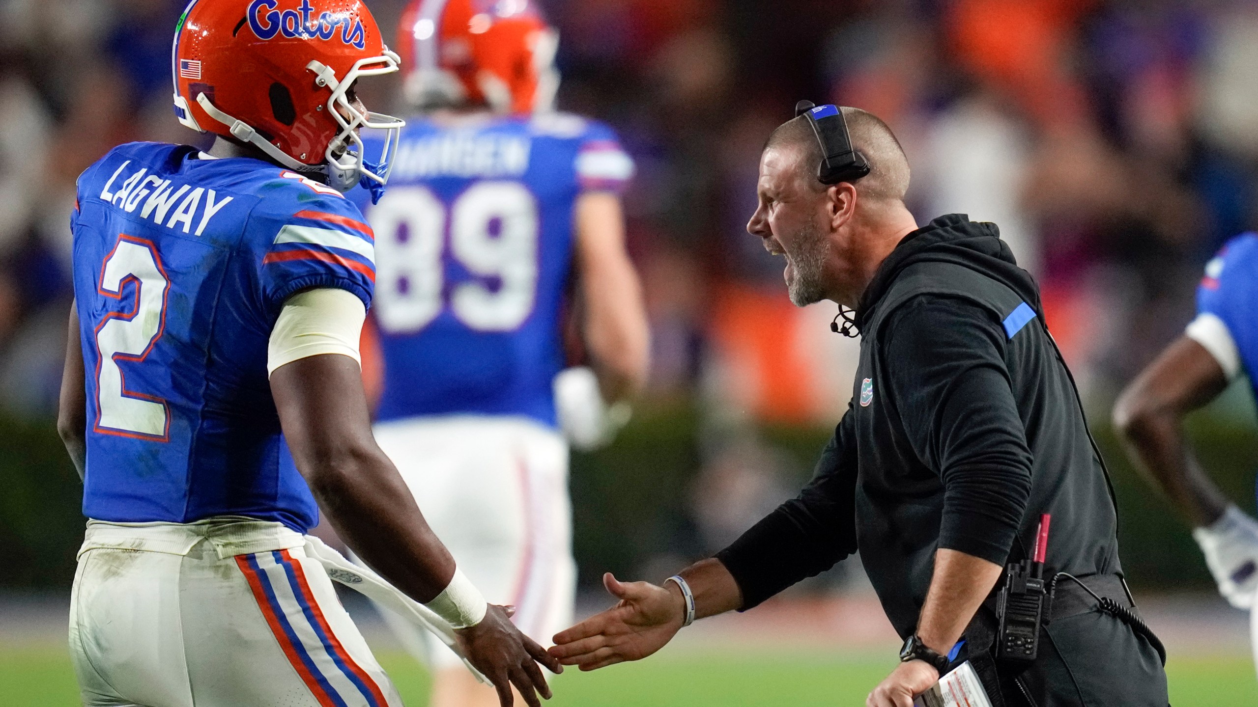 Florida head coach Billy Napier, right, greets quarterback DJ Lagway (2) as he comes off the field during the first half of an NCAA college football game against Kentucky, Saturday, Oct. 19, 2024, in Gainesville, Fla. (AP Photo/John Raoux)