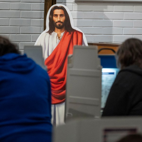 A cutout of Jesus watches over voters at the voting station at Redeemer Lutheran Church on Election Day, Tuesday, Nov. 5, 2024, in Lincoln, Neb. (Kenneth Ferriera/Lincoln Journal Star via AP)