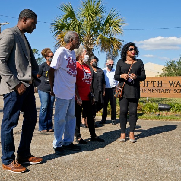 FILE - EPA Administrator Michael Regan, left, arrives at the Fifth Ward Elementary School, which is near the Denka plant, with Robert Taylor, second left, founder of Concerned Citizens of St. John's Parish, and Lydia Gerard, third left, a member of the group, in Reserve, La., Nov. 16, 2021. (AP Photo/Gerald Herbert, File)