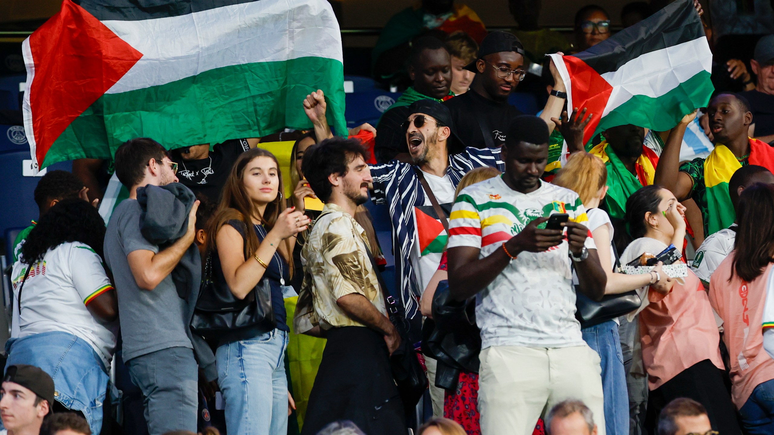 FILE - Spectators hold Palestinian flags as they watch the men's group D match between Israel and Mali at the Parc des Princes during the 2024 Summer Olympics, Wednesday, July 24, 2024, in Paris, France. (AP Photo/Aurelien Morissard, File)