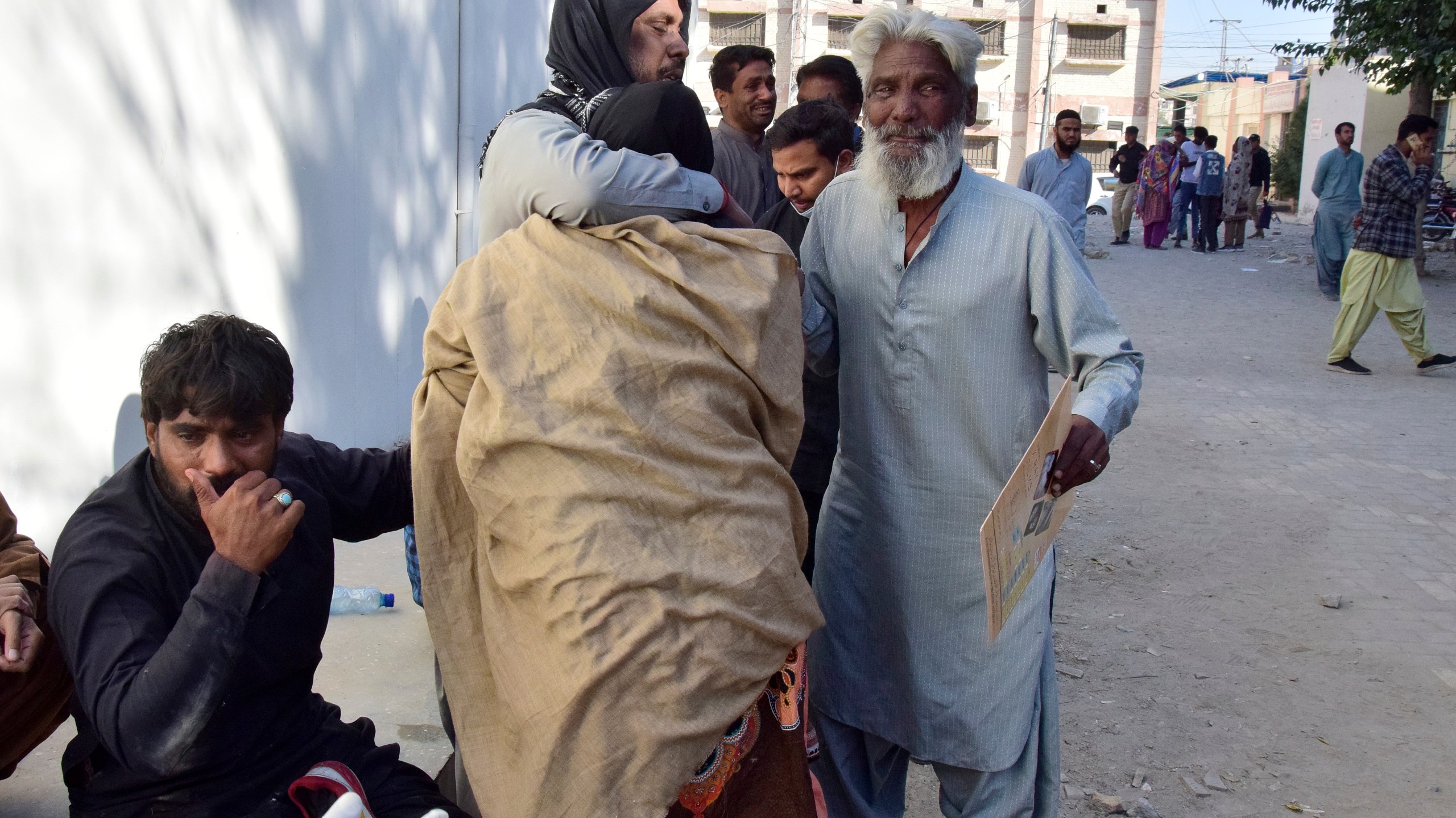 People comfort each others as they mourn for their relatives, who died in a bomb explosion at railway station, outside a hospital in Quetta, southwestern Pakistan, Saturday, Nov. 9, 2024. (AP Photo/Arshad Butt)