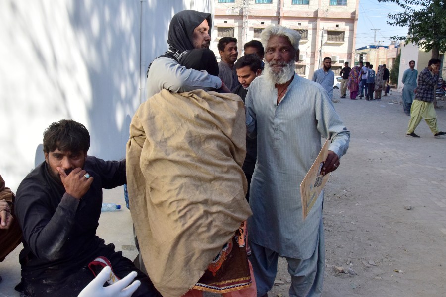 People comfort each others as they mourn for their relatives, who died in a bomb explosion at railway station, outside a hospital in Quetta, southwestern Pakistan, Saturday, Nov. 9, 2024. (AP Photo/Arshad Butt)