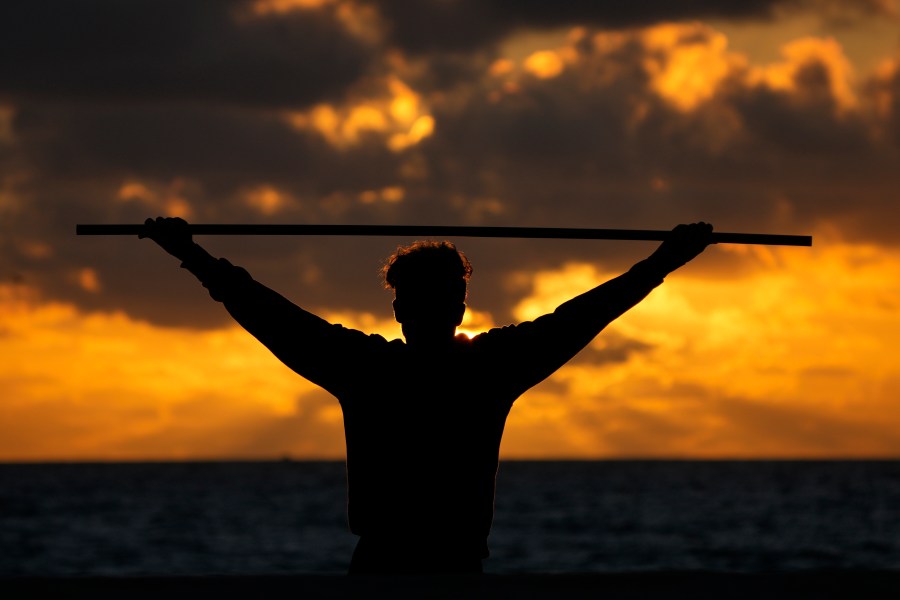 FILE - A beach goer exercises as the sun rises above the Atlantic Ocean, Feb. 1, 2023, in Surfside, Fla. (AP Photo/Wilfredo Lee, File)