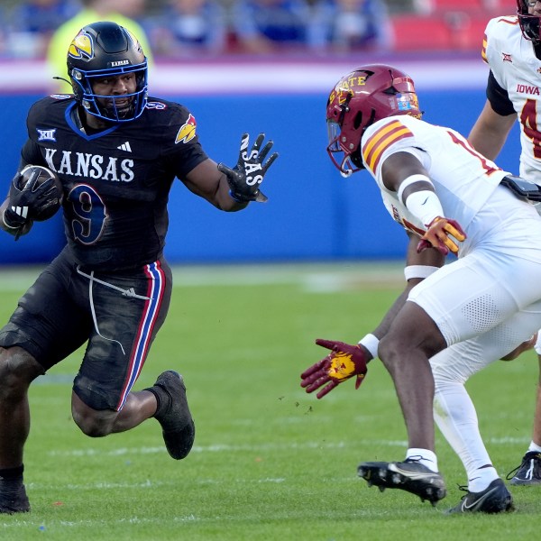 Kansas running back Daniel Hishaw Jr. (9) gets past Iowa State defensive back Ta'Shawn James during the first half of an NCAA college football game Saturday, Nov. 9, 2024, in Kansas City, Mo. (AP Photo/Charlie Riedel)