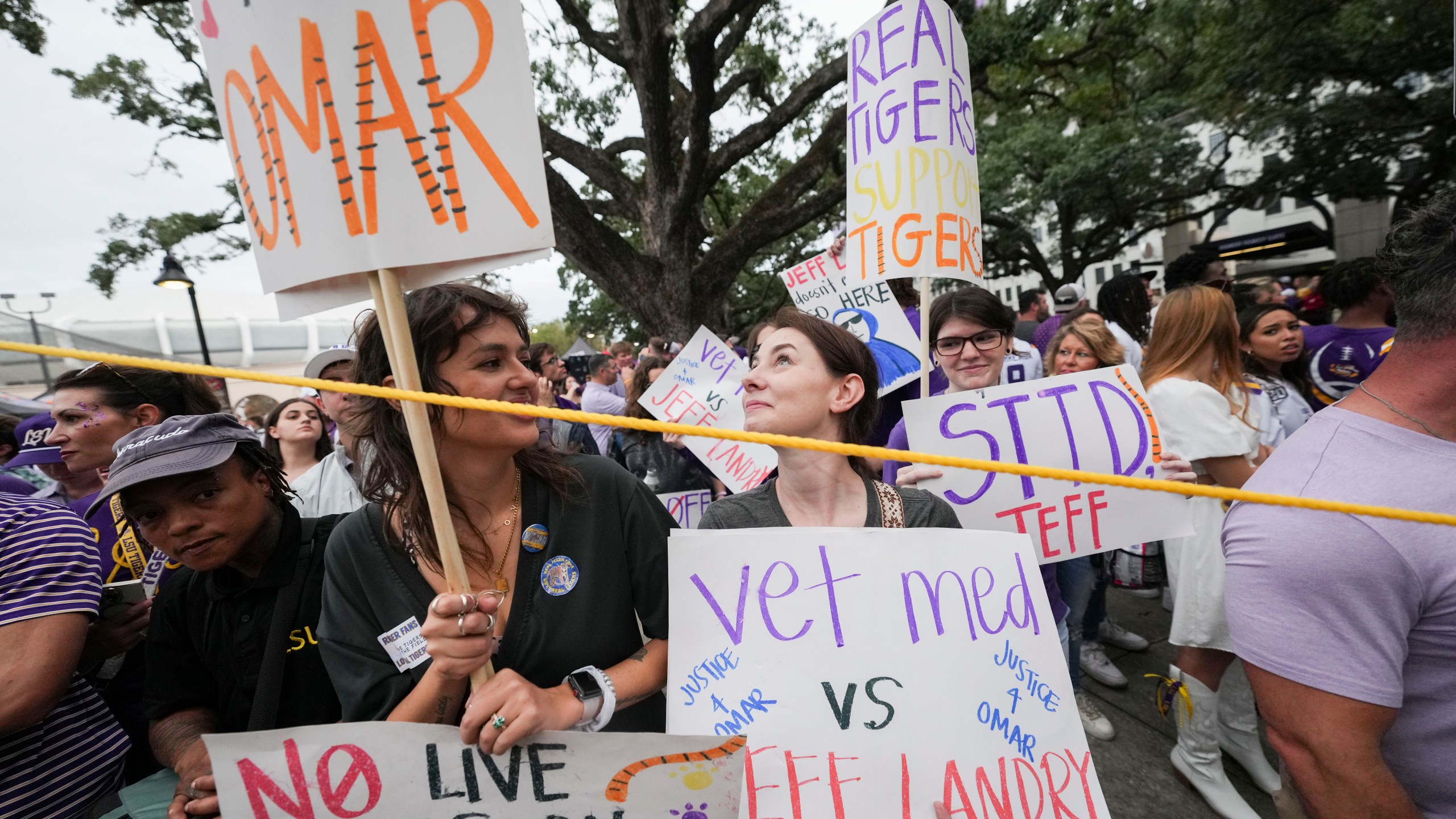 Haley Betz, Lauren Hausey and Camille Evans, veterinary technicians, protest the use of plans to use a live tiger as a mascot in the stadium, before an NCAA college football game between LSU and Alabama in Baton Rouge, La., Saturday, Nov. 9, 2024. (AP Photo/Gerald Herbert)