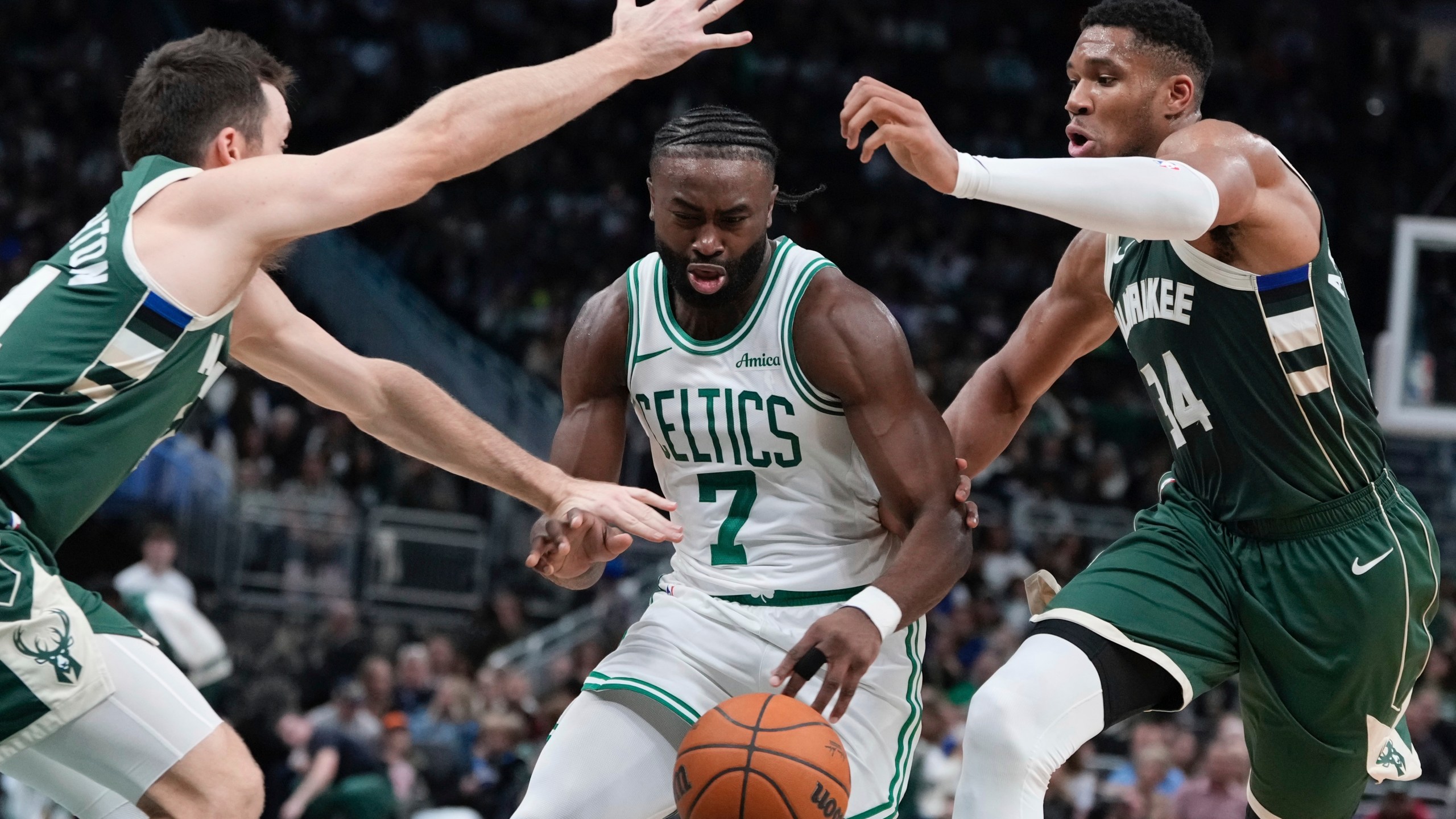 Boston Celtics' Jaylen Brown drives between Milwaukee Bucks' Pat Connaughton and Giannis Antetokounmpo during the first half of an NBA basketball game Sunday, Nov. 10, 2024, in Milwaukee. (AP Photo/Morry Gash)