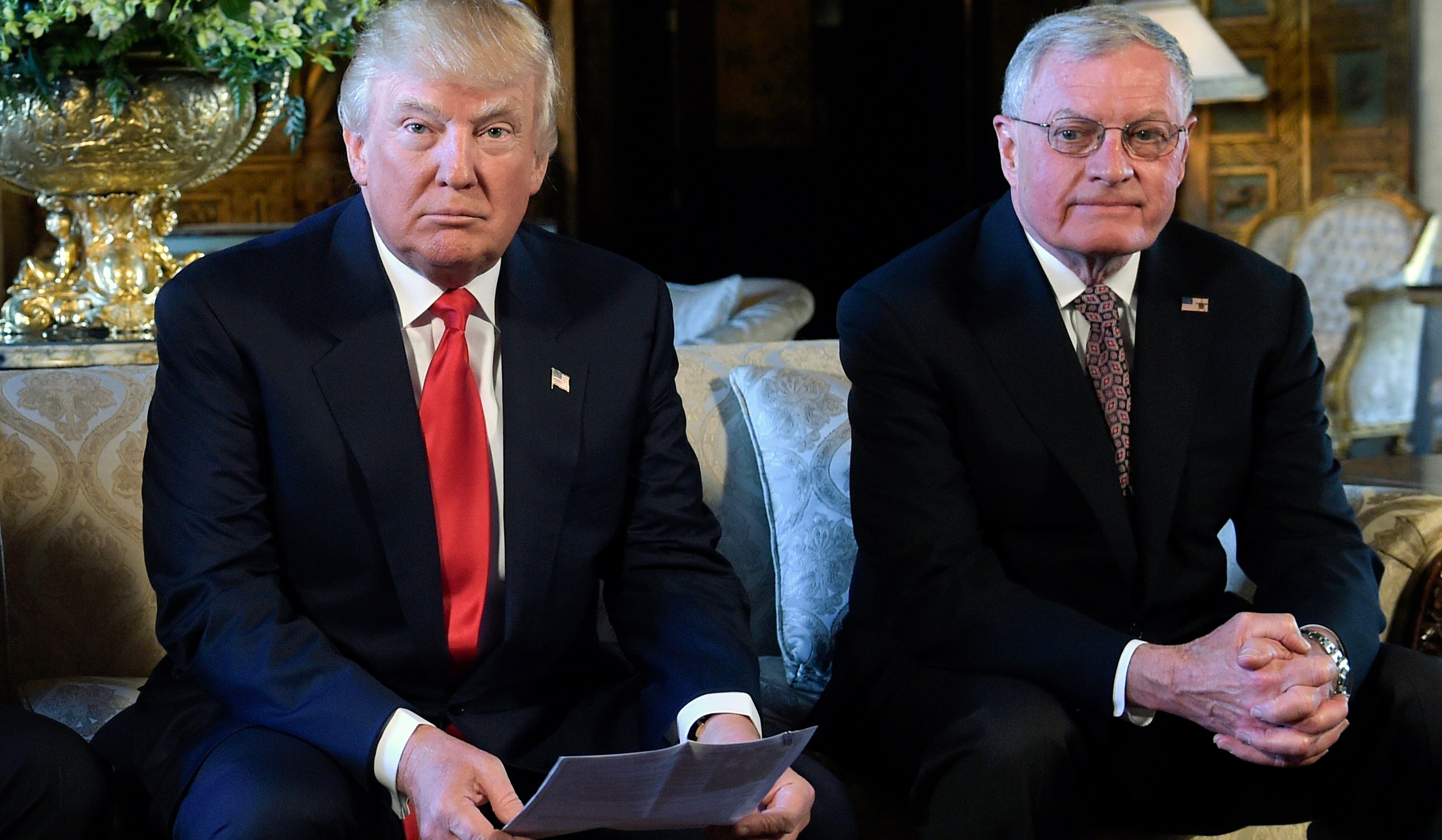 FILE - President Donald Trump, center, sits with retired Army Lt. Gen. Keith Kellogg, right, at Trump's Mar-a-Lago estate in Palm Beach, Fla., Feb. 20, 2017. President-elect Donald Trump’s choice for defense secretary is still up in the air, but it’s a sure bet he will look to pick a loyalist following his tumultuous first term. (AP Photo/Susan Walsh, File)