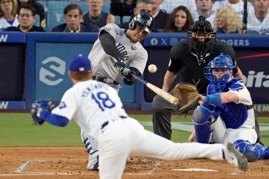 New York Yankees' Juan Soto, center, hits a home run off Los Angeles Dodgers starting pitcher Yoshinobu Yamamoto (18) during the third inning in Game 2 of the baseball World Series, Saturday, Oct. 26, 2024, in Los Angeles. (AP Photo/Julio Cortez)