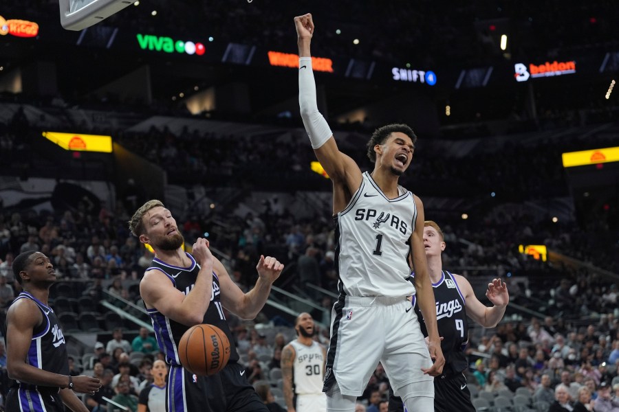 San Antonio Spurs center Victor Wembanyama (1) reacts as he scores over Sacramento Kings forward Domantas Sabonis (11) during the second half of an NBA basketball game in San Antonio, Monday, Nov. 11, 2024. (AP Photo/Eric Gay)