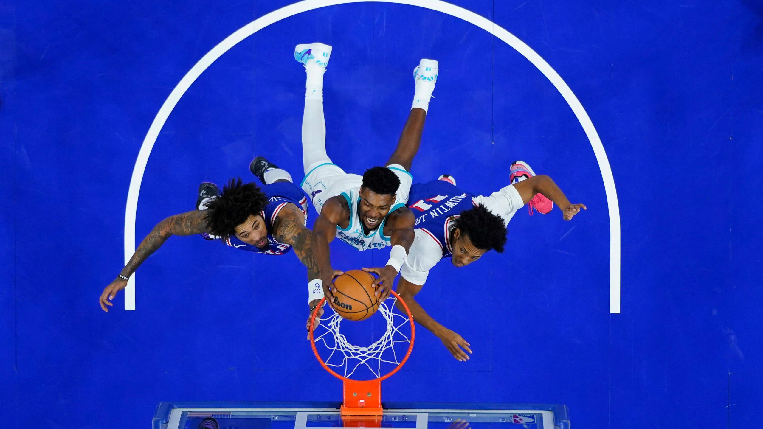 Charlotte Hornets' Brandon Miller, center, dunks between Philadelphia 76ers' Kelly Oubre Jr., left, and Jeff Dowtin Jr. during the second half of an NBA basketball game, Sunday, Nov. 10, 2024, in Philadelphia. (AP Photo/Matt Slocum)