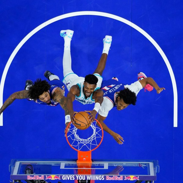 Charlotte Hornets' Brandon Miller, center, dunks between Philadelphia 76ers' Kelly Oubre Jr., left, and Jeff Dowtin Jr. during the second half of an NBA basketball game, Sunday, Nov. 10, 2024, in Philadelphia. (AP Photo/Matt Slocum)