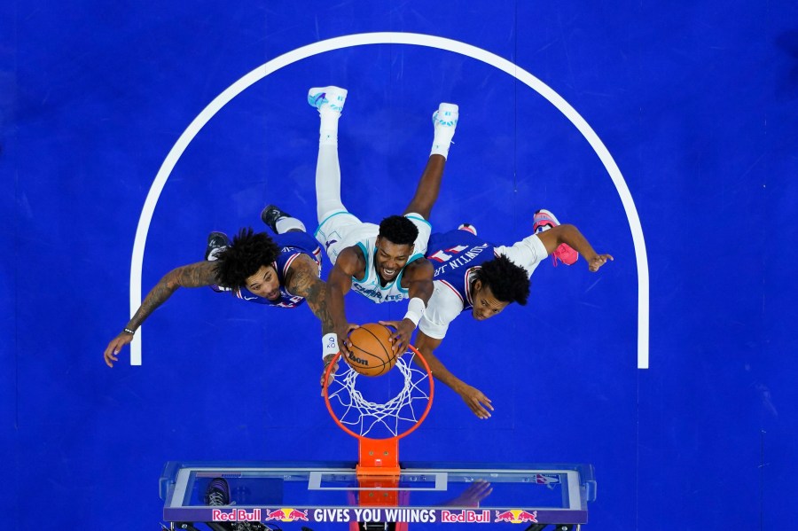 Charlotte Hornets' Brandon Miller, center, dunks between Philadelphia 76ers' Kelly Oubre Jr., left, and Jeff Dowtin Jr. during the second half of an NBA basketball game, Sunday, Nov. 10, 2024, in Philadelphia. (AP Photo/Matt Slocum)