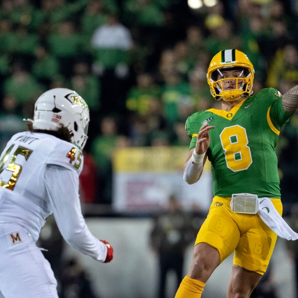 Oregon quarterback Dillon Gabriel (8) throws the ball as Maryland linebacker Kellan Wyatt (45) defends during the second half of an NCAA college football game on Saturday, Nov. 9, 2024, in Eugene, Ore. Oregon won 39-18. (AP Photo/Jenny Kane)