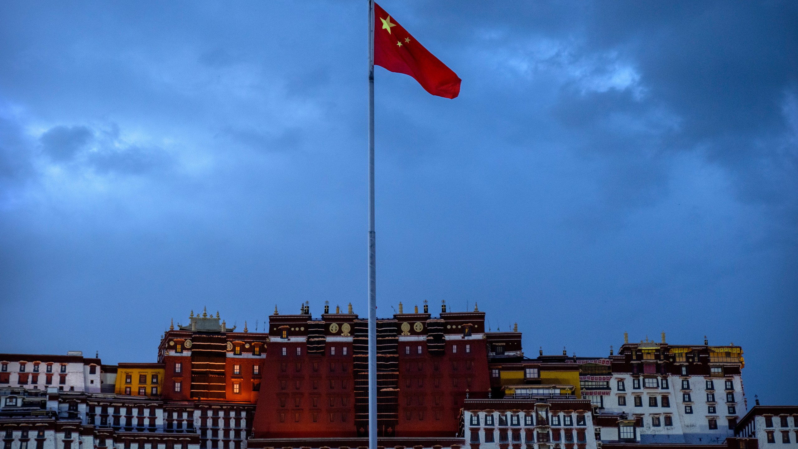 FILE- The Chinese flag flies at a plaza near the Potala Palace in Lhasa in western China's Tibet Autonomous Region, June 1, 2021, as seen during a government organized visit for foreign journalists. (AP Photo/Mark Schiefelbein, File)