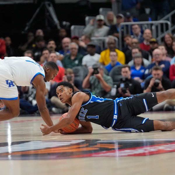 Duke guard Caleb Foster (1) and Kentucky guard Lamont Butler (1) dive for a loose ball during the first half of an NCAA college basketball game, Tuesday, Nov. 12, 2024, in Atlanta. (AP Photo/John Bazemore )