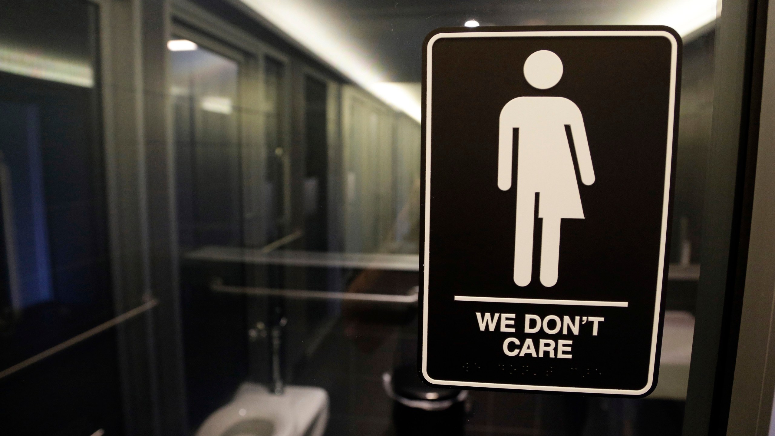 FILE - Signage hangs outside a restroom at 21c Museum Hotel in Durham, N.C., May 12, 2016. (AP Photo/Gerry Broome, File)