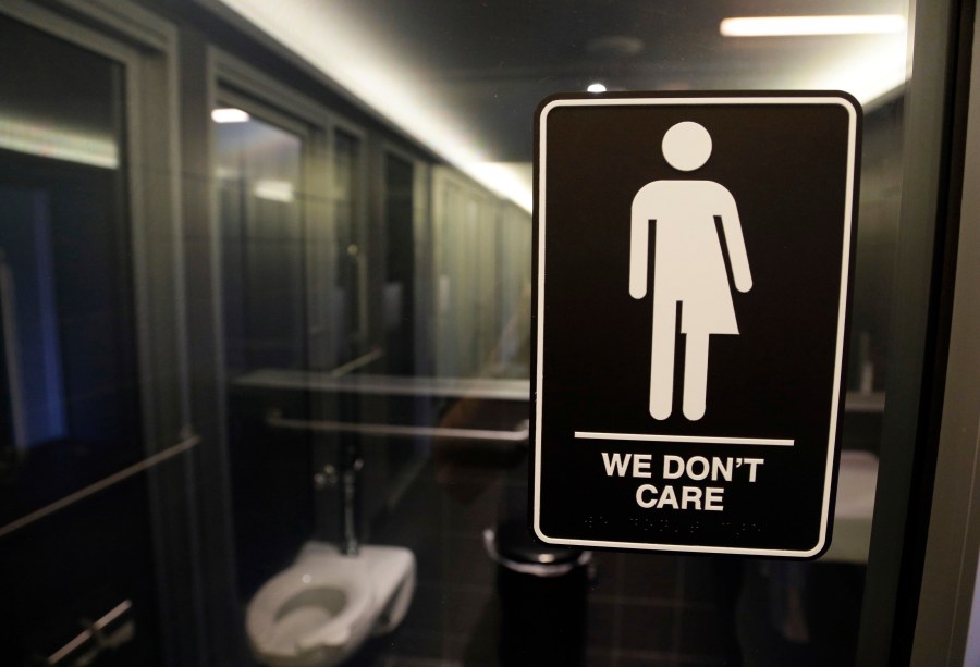 FILE - Signage hangs outside a restroom at 21c Museum Hotel in Durham, N.C., May 12, 2016. (AP Photo/Gerry Broome, File)