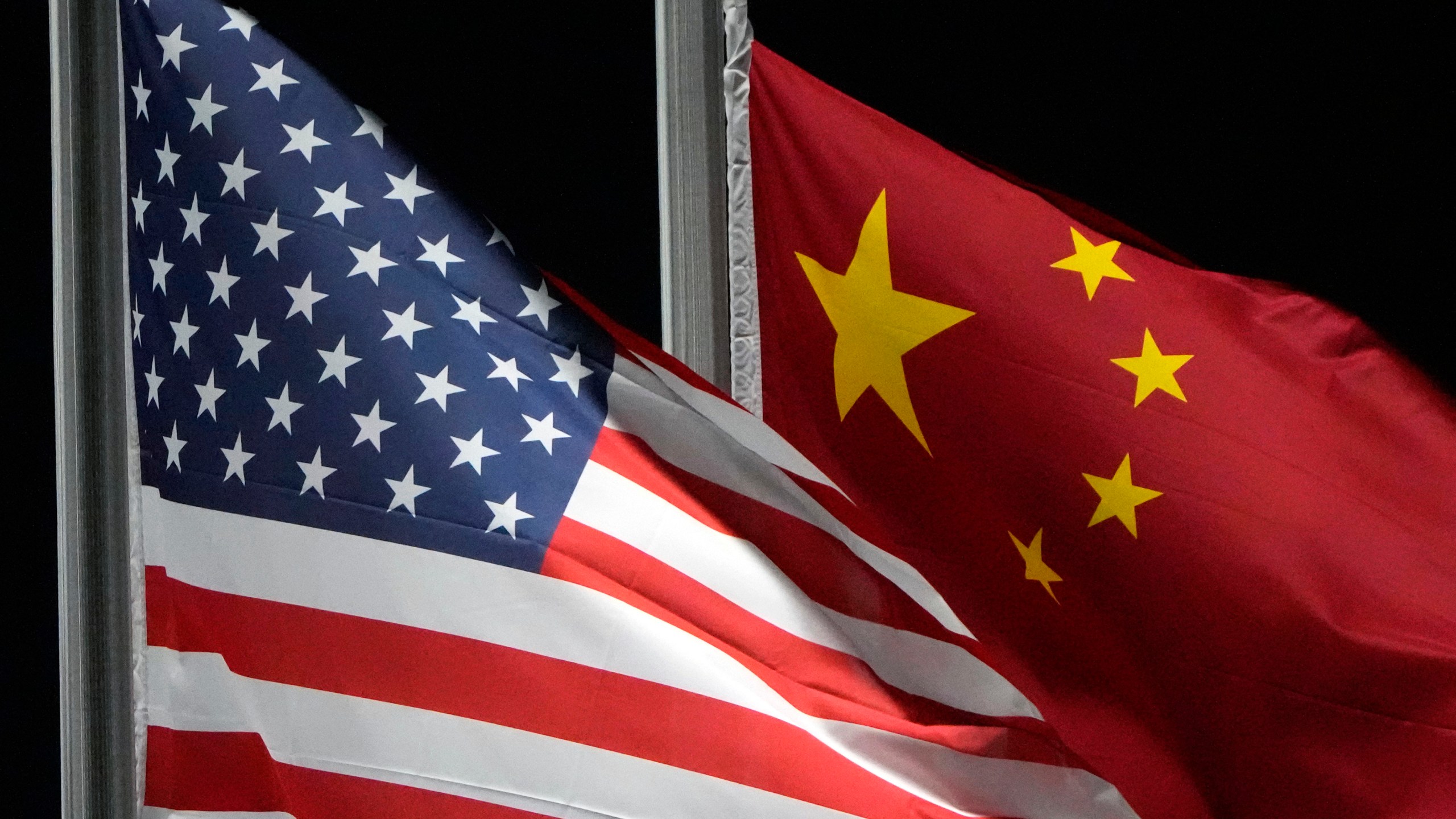 FILE - The American and Chinese flags wave at Genting Snow Park, Feb. 2, 2022, in Zhangjiakou, China. (AP Photo/Kiichiro Sato, File)