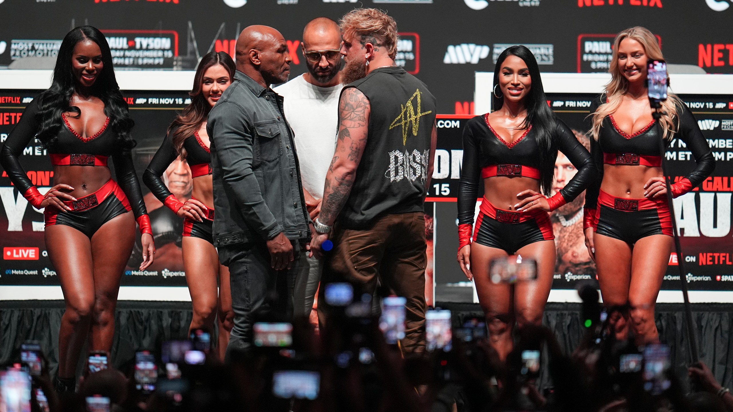 Mike Tyson, front left, and Jake Paul, front right, face off during a news conference ahead of their fight, Wednesday, Nov. 13, 2024, in Irving, Texas. (AP Photo/Julio Cortez)