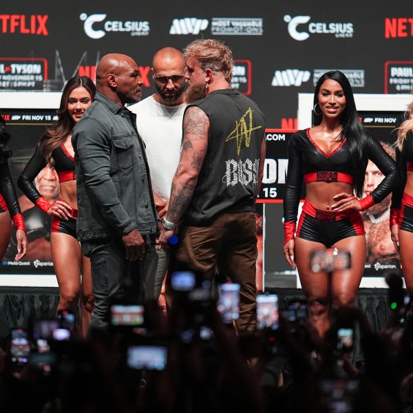 Mike Tyson, front left, and Jake Paul, front right, face off during a news conference ahead of their fight, Wednesday, Nov. 13, 2024, in Irving, Texas. (AP Photo/Julio Cortez)