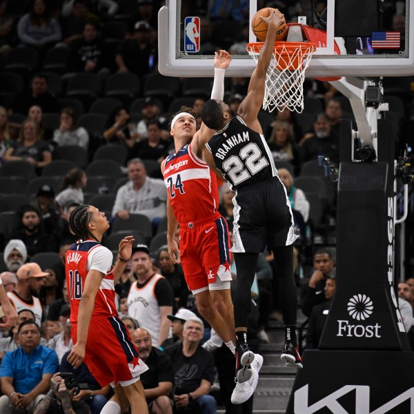 San Antonio Spurs' Malaki Branham (22) dunks against Washington Wizards' Corey Kispert (24) during the first half of an NBA basketball game, Wednesday, Nov. 13, 2024, in San Antonio. (AP Photo/Darren Abate)