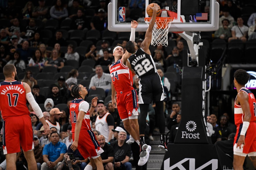 San Antonio Spurs' Malaki Branham (22) dunks against Washington Wizards' Corey Kispert (24) during the first half of an NBA basketball game, Wednesday, Nov. 13, 2024, in San Antonio. (AP Photo/Darren Abate)