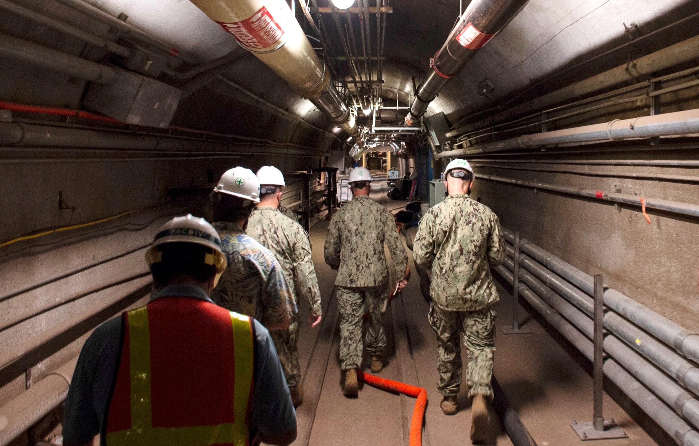 FILE - In this photo provided by the U.S. Navy, Rear Adm. John Korka, Commander, Naval Facilities Engineering Systems Command (NAVFAC), and Chief of Civil Engineers, leads Navy and civilian water quality recovery experts through the tunnels of the Red Hill Bulk Fuel Storage Facility, near Pearl Harbor, Hawaii, on Dec. 23, 2021. (Mass Communication Specialist 1st Class Luke McCall/U.S. Navy via AP, File)