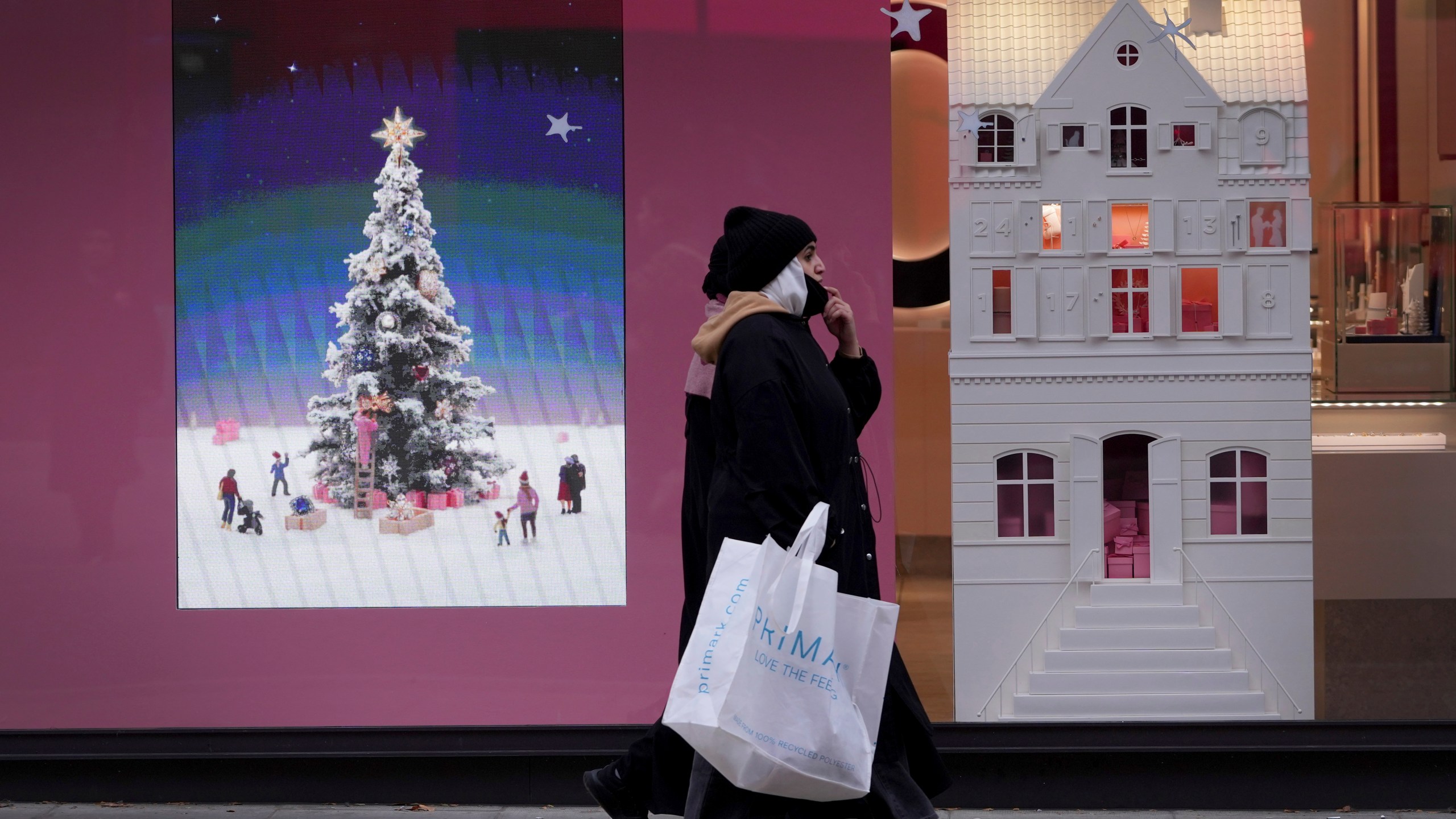 Shoppers pass a festive shop window in Oxford Street in London. Friday, Nov. 15, 2024. (AP Photo/Kirsty Wigglesworth)