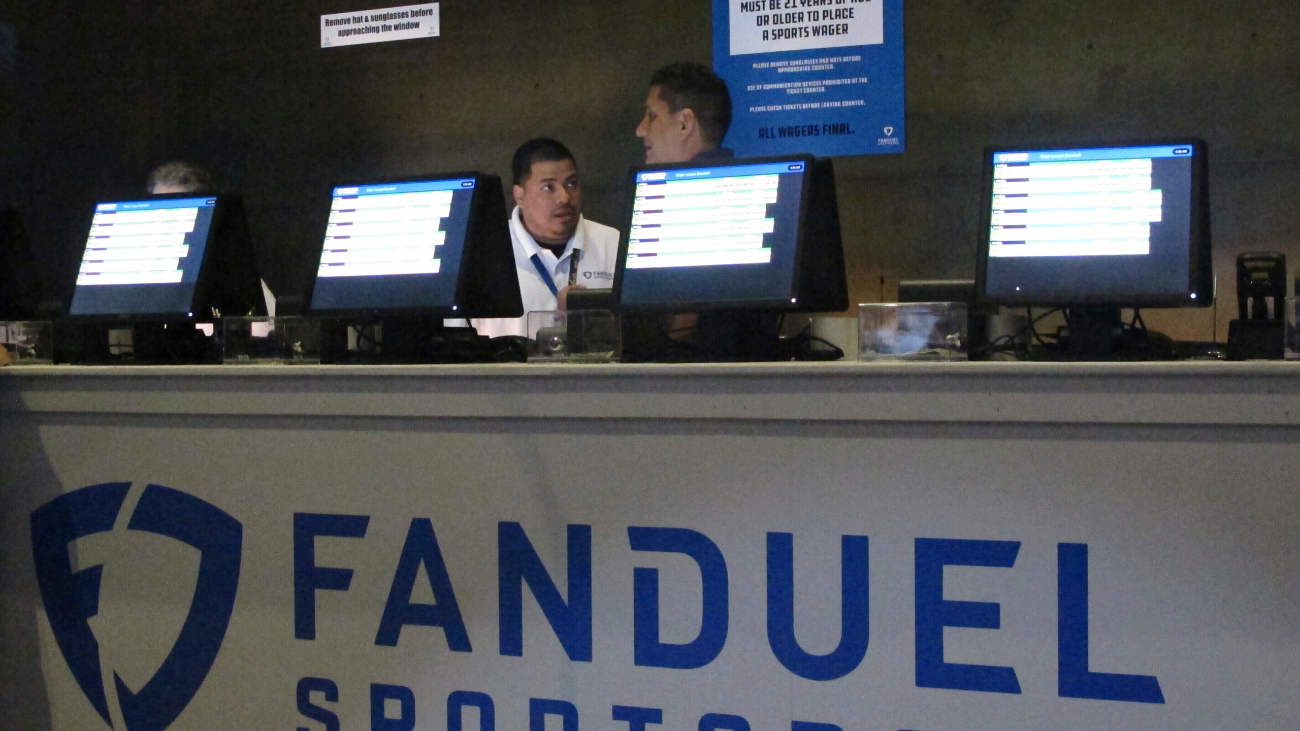 FILE - Workers at the FanDuel sports book at the Meadowlands Racetrack in East Rutherford, N.J., prepare to take bets, July 14, 2018. (AP Photo/Wayne Parry, File)