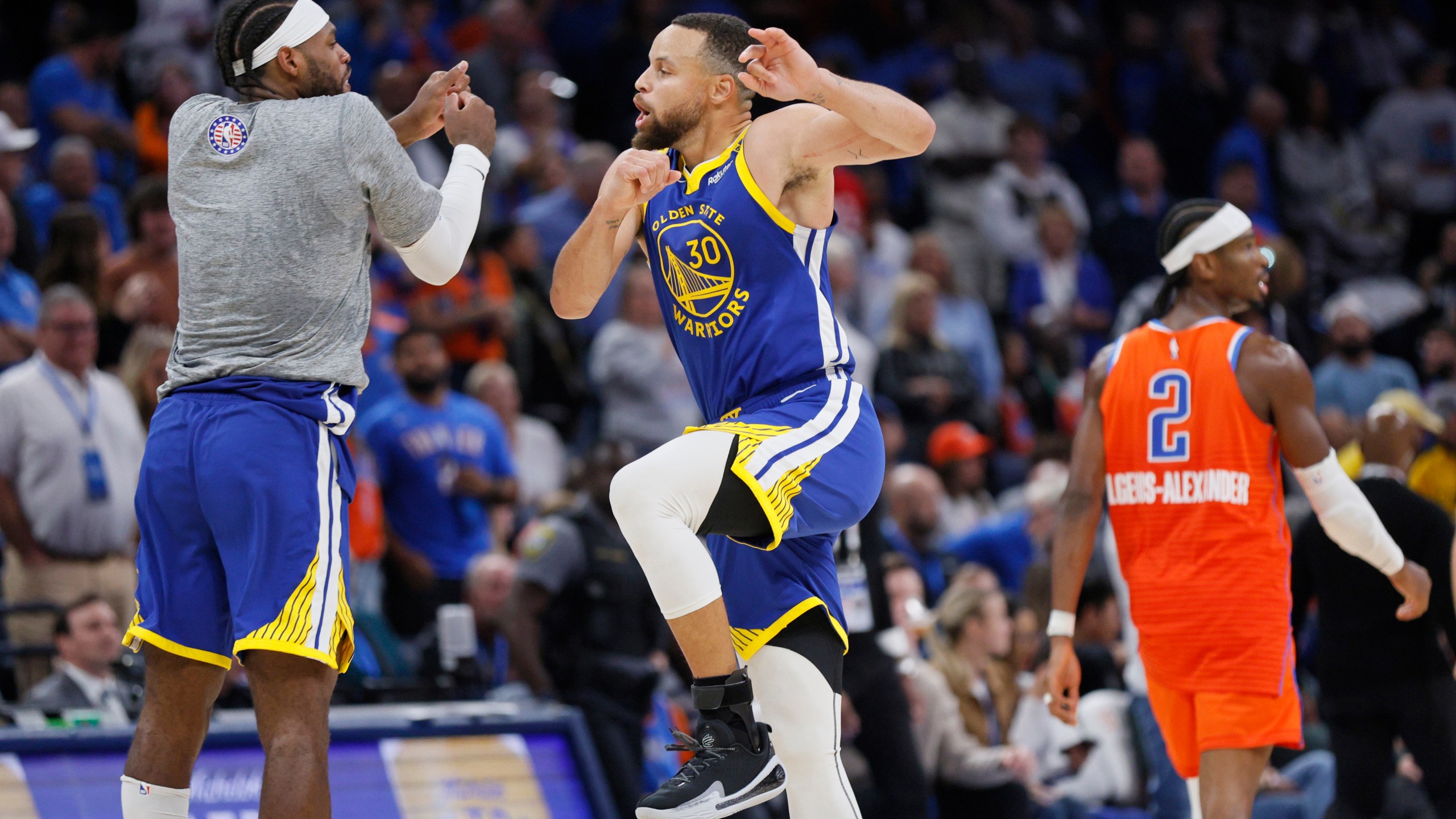 Golden State Warriors guard Buddy Hield, left, and Golden State Warriors guard Stephen Curry (30) celebrate as Oklahoma City Thunder guard Shai Gilgeous-Alexander (2) leaves the court during the second half of an NBA basketball game Sunday, Nov. 10, 2024, in Oklahoma City. (AP Photo/Nate Billings)