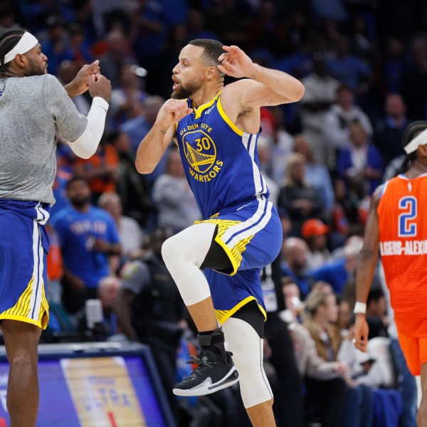 Golden State Warriors guard Buddy Hield, left, and Golden State Warriors guard Stephen Curry (30) celebrate as Oklahoma City Thunder guard Shai Gilgeous-Alexander (2) leaves the court during the second half of an NBA basketball game Sunday, Nov. 10, 2024, in Oklahoma City. (AP Photo/Nate Billings)