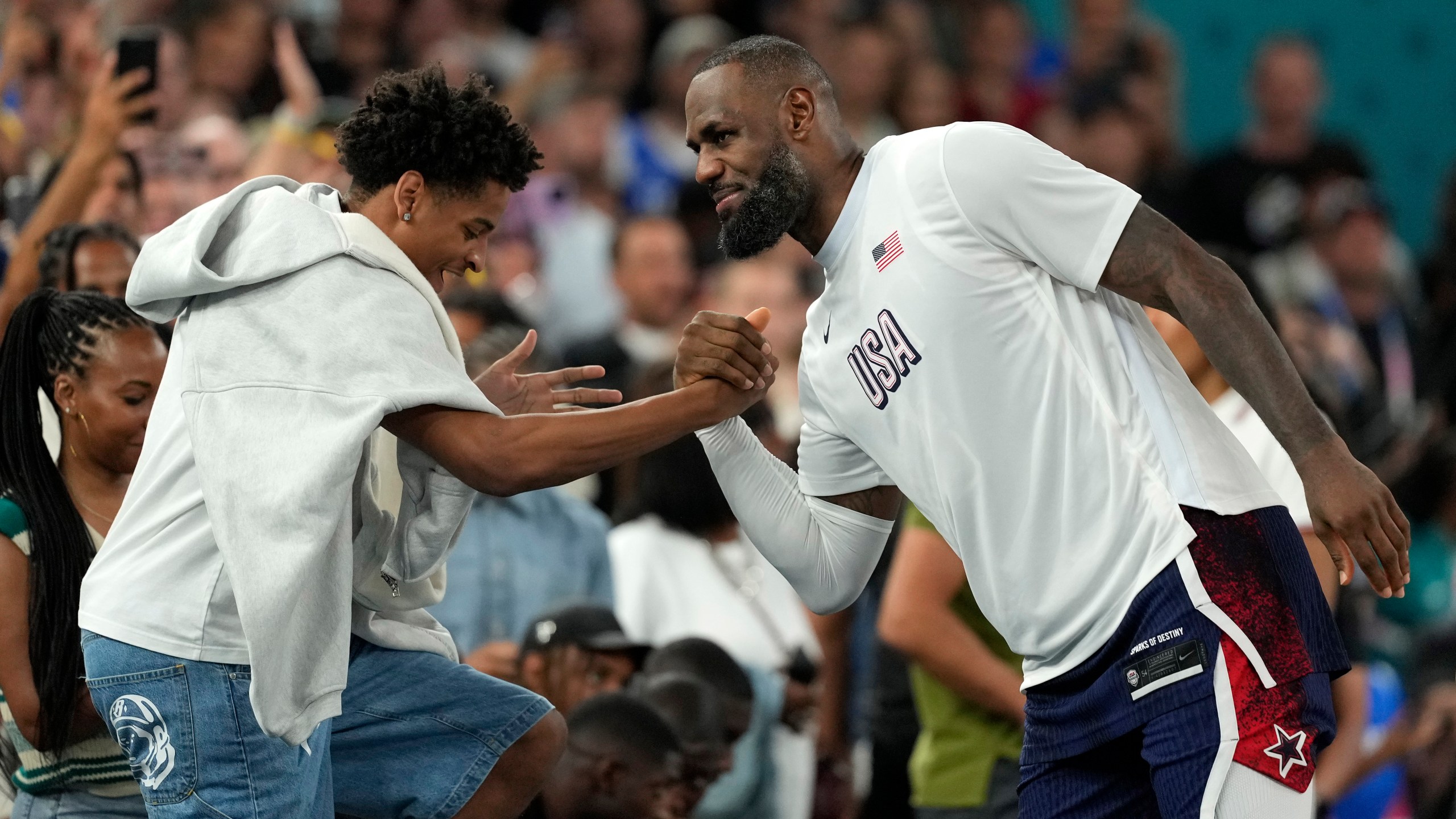 FILE - Kiyan Anthony, left, son of Carmelo Anthony, greets United States' LeBron James after the United States defeated Brazil in a men's basketball game at the 2024 Summer Olympics, Aug. 6, 2024, in Paris, France. (AP Photo/Michael Conroy, File)