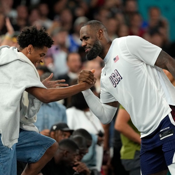 FILE - Kiyan Anthony, left, son of Carmelo Anthony, greets United States' LeBron James after the United States defeated Brazil in a men's basketball game at the 2024 Summer Olympics, Aug. 6, 2024, in Paris, France. (AP Photo/Michael Conroy, File)