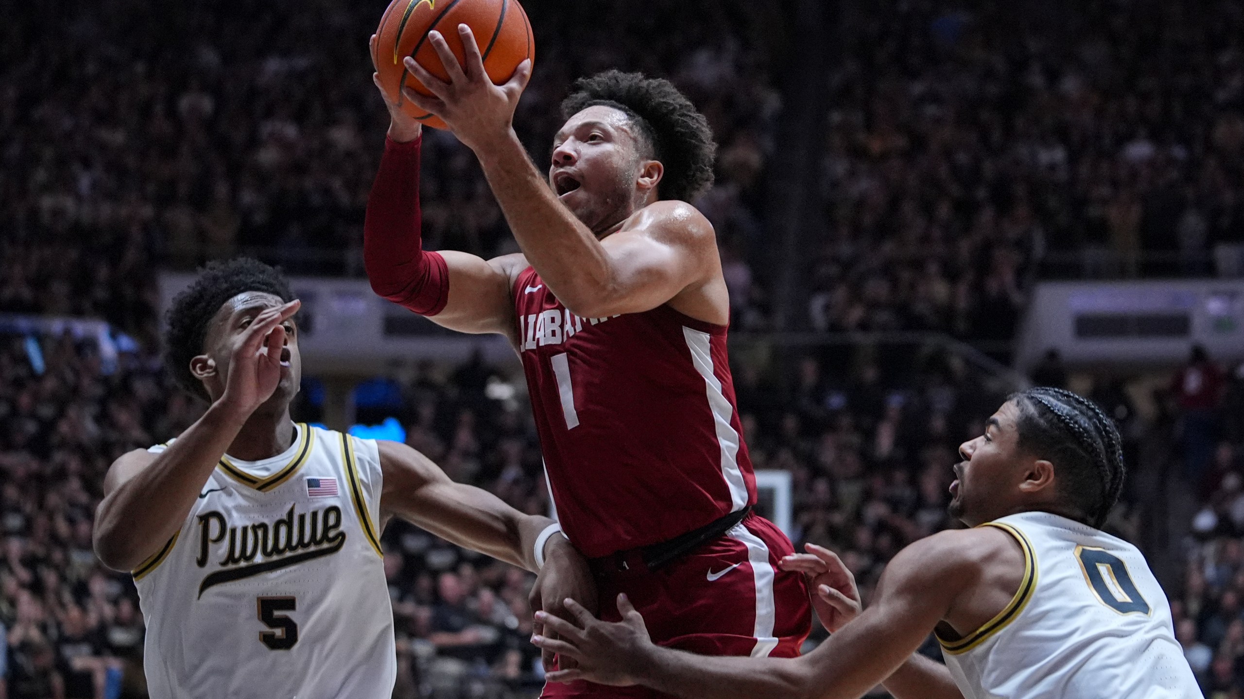 Alabama guard Mark Sears (1) shoots between Purdue guard Myles Colvin (5) and guard C.J. Cox (0) during the first half of an NCAA college basketball game in West Lafayette, Ind., Friday, Nov. 15, 2024. (AP Photo/Michael Conroy)