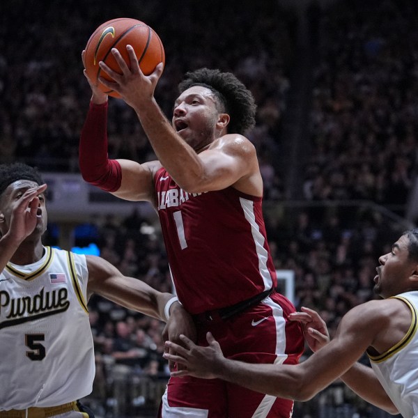 Alabama guard Mark Sears (1) shoots between Purdue guard Myles Colvin (5) and guard C.J. Cox (0) during the first half of an NCAA college basketball game in West Lafayette, Ind., Friday, Nov. 15, 2024. (AP Photo/Michael Conroy)