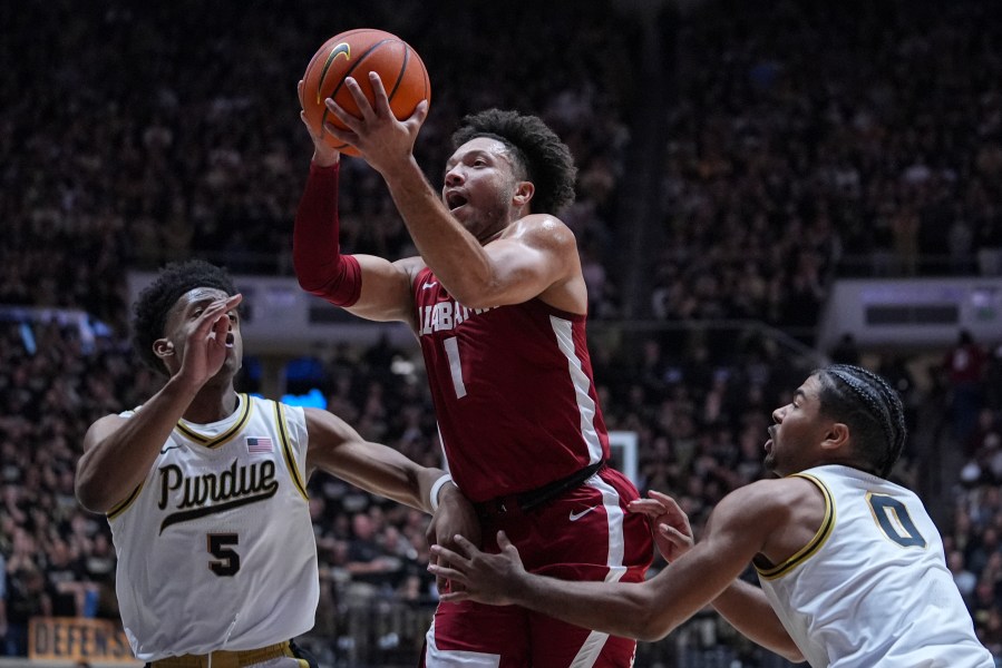 Alabama guard Mark Sears (1) shoots between Purdue guard Myles Colvin (5) and guard C.J. Cox (0) during the first half of an NCAA college basketball game in West Lafayette, Ind., Friday, Nov. 15, 2024. (AP Photo/Michael Conroy)