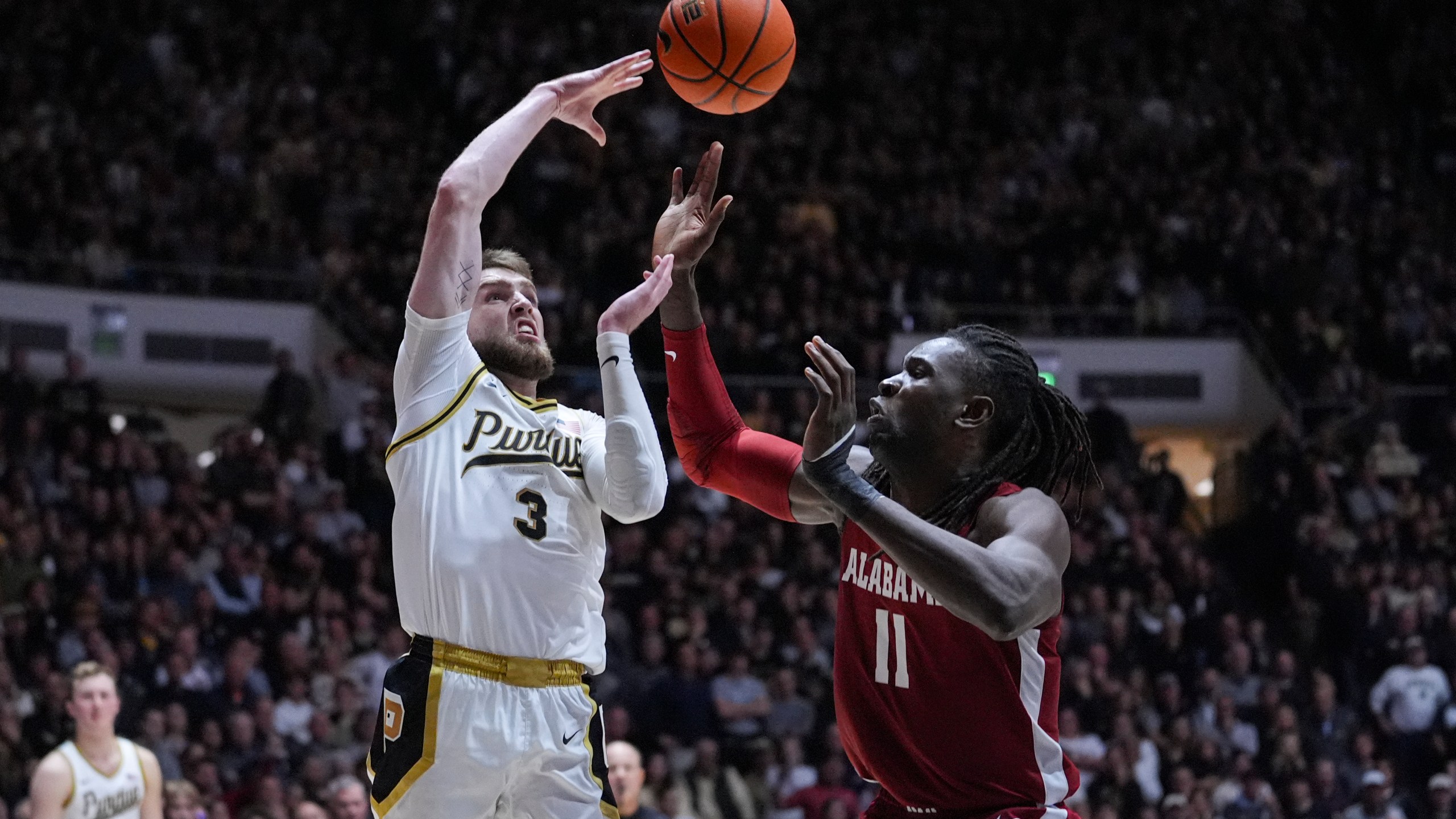 Purdue guard Braden Smith (3) makes a pass over Alabama center Clifford Omoruyi (11) during the second half of an NCAA college basketball game in West Lafayette, Ind., Friday, Nov. 15, 2024. (AP Photo/Michael Conroy)