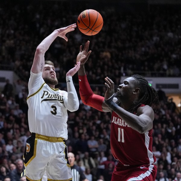 Purdue guard Braden Smith (3) makes a pass over Alabama center Clifford Omoruyi (11) during the second half of an NCAA college basketball game in West Lafayette, Ind., Friday, Nov. 15, 2024. (AP Photo/Michael Conroy)