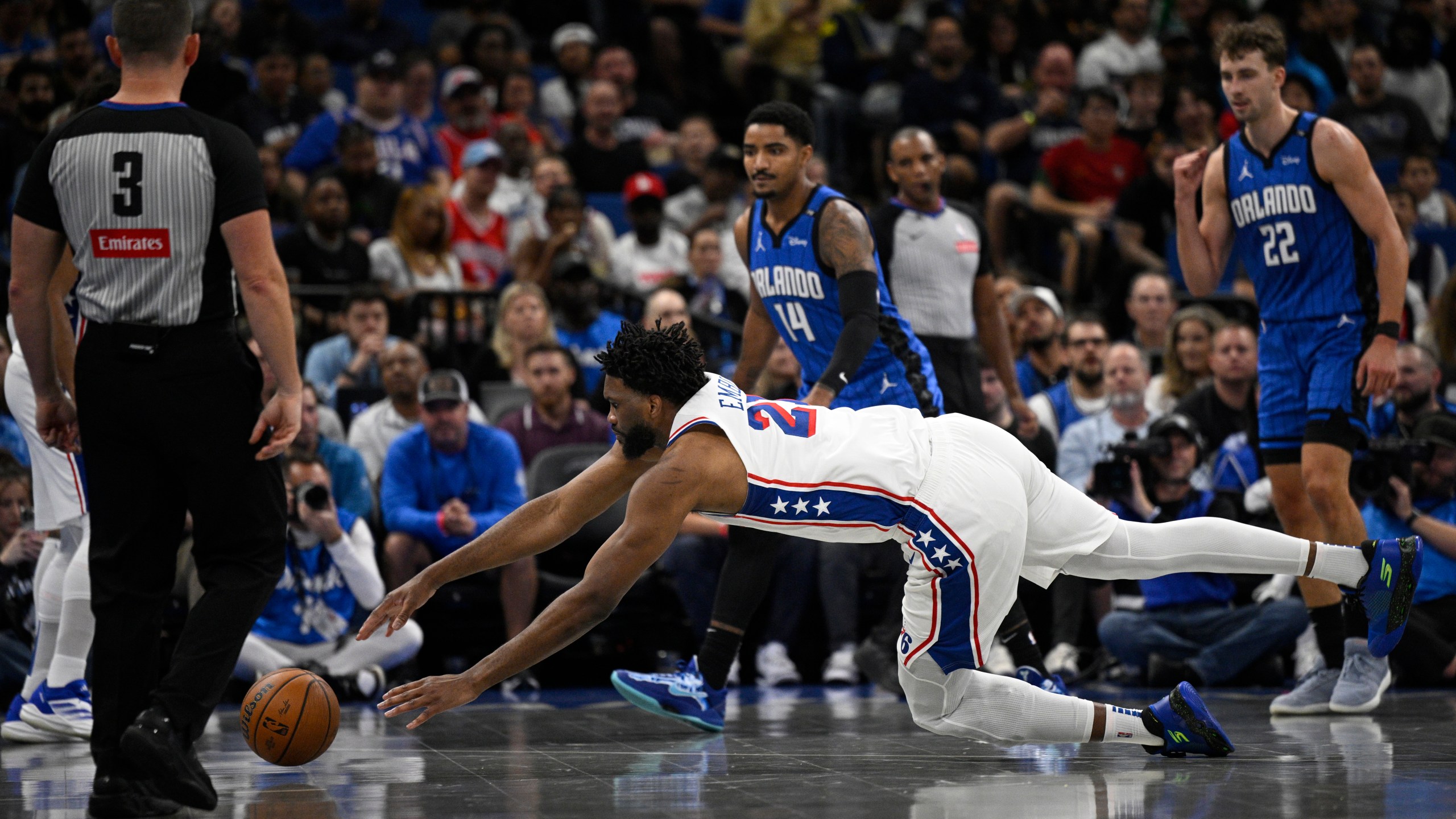 Philadelphia 76ers center Joel Embiid (21) dives after a loose ball against the Orlando Magic during the first half of an Emirates NBA Cup basketball game, Friday, Nov. 15, 2024, in Orlando, Fla. (AP Photo/Phelan M. Ebenhack)