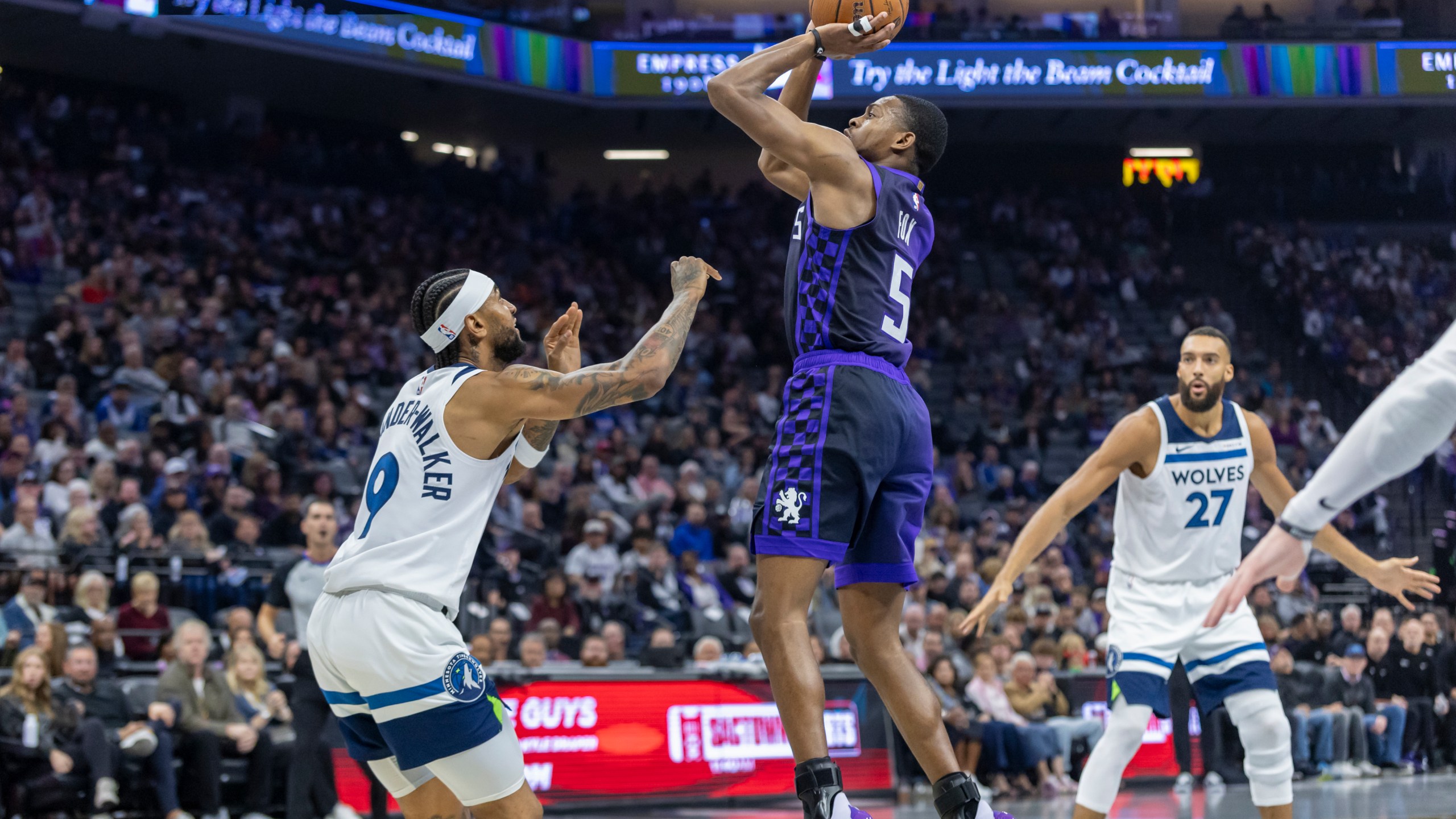 Sacramento Kings guard De'Aaron Fox (5) makes a jump shot over Minnesota Timberwolves guard Nickeil Alexander-Walker (9) during the first half of an Emirates NBA Cup basketball game Friday, Nov. 15, 2024, in Sacramento, Calif. (AP Photo/Sara Nevis)