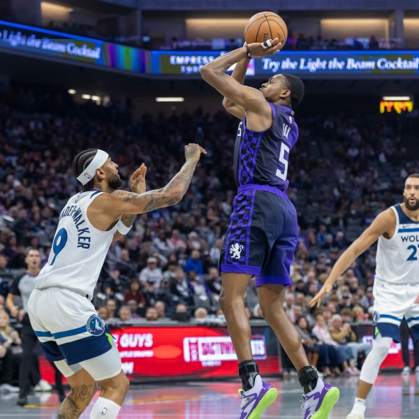 Sacramento Kings guard De'Aaron Fox (5) makes a jump shot over Minnesota Timberwolves guard Nickeil Alexander-Walker (9) during the first half of an Emirates NBA Cup basketball game Friday, Nov. 15, 2024, in Sacramento, Calif. (AP Photo/Sara Nevis)