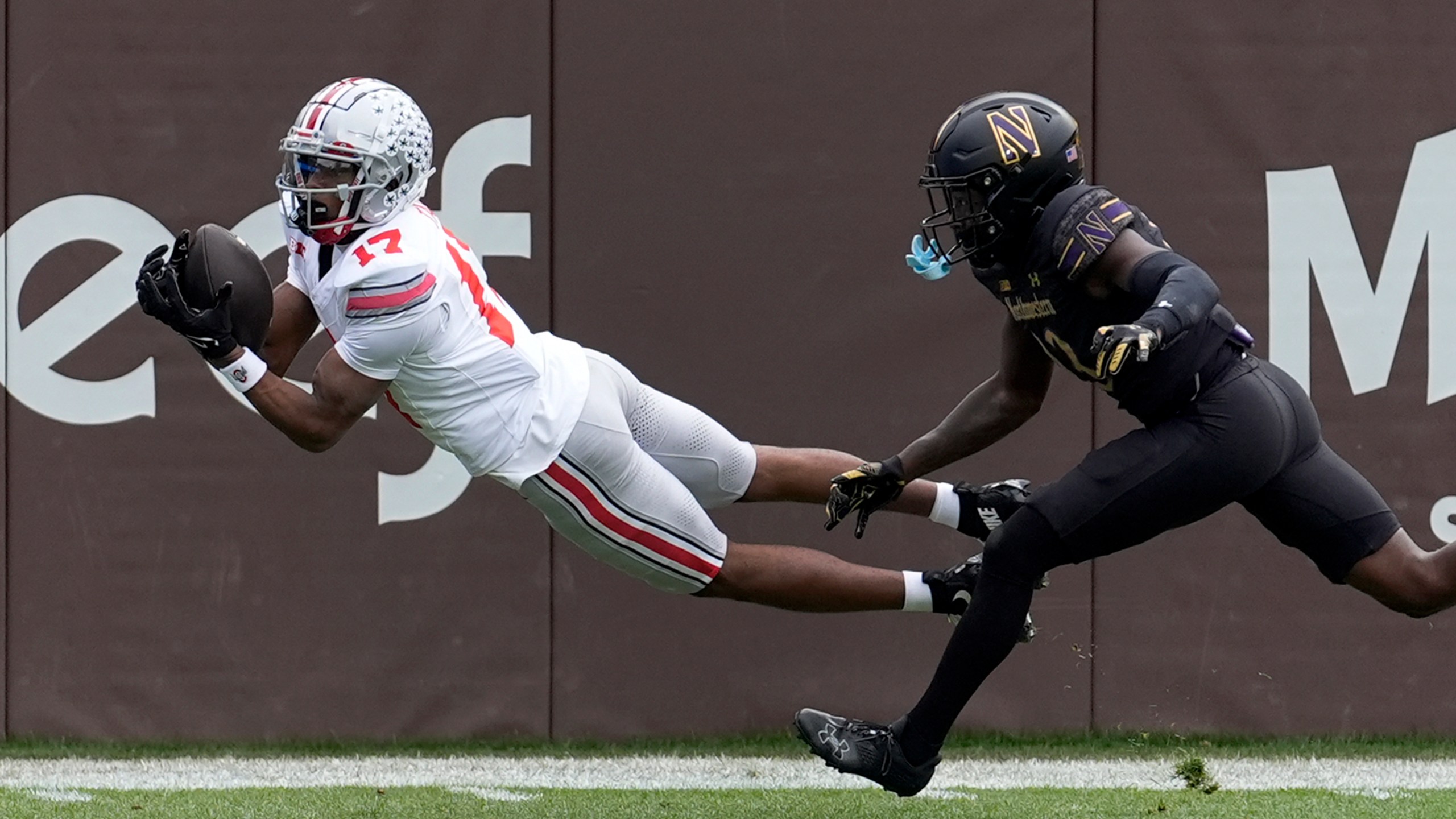 Ohio State wide receiver Carnell Tate State lays out for a touchdown pass as Northwestern defensive back Josh Fussell defends during the first half of an NCAA college football game at Wrigley Field on Saturday, Nov. 16, 2024, in Chicago. (AP Photo/Charles Rex Arbogast)