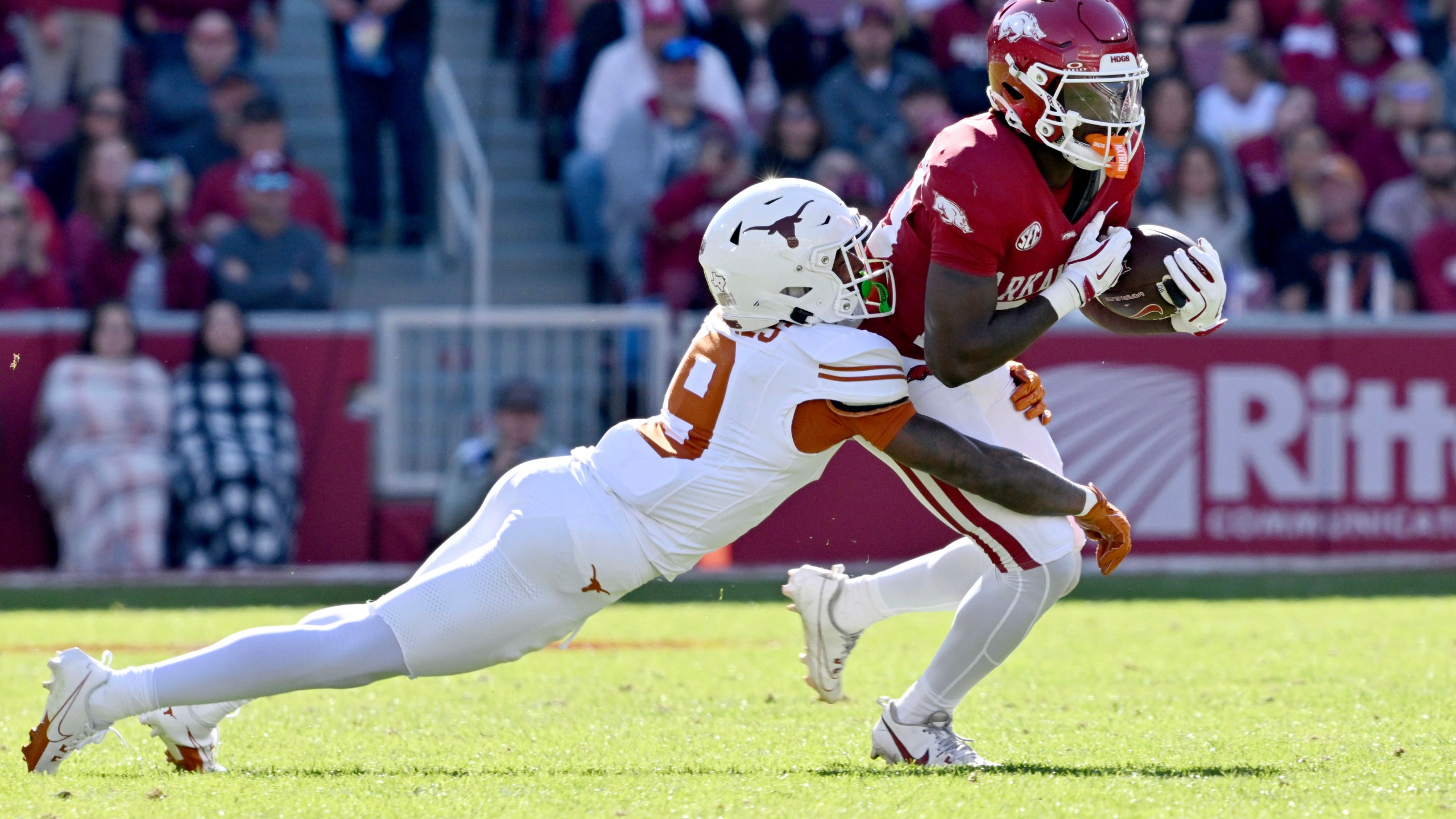 Arkansas running back Rodney Hill (20) is tackled by Texas defensive back Gavin Holmes (9) during the first half of an NCAA college football game Saturday, Nov. 16, 2024, in Fayetteville, Ark. (AP Photo/Michael Woods)