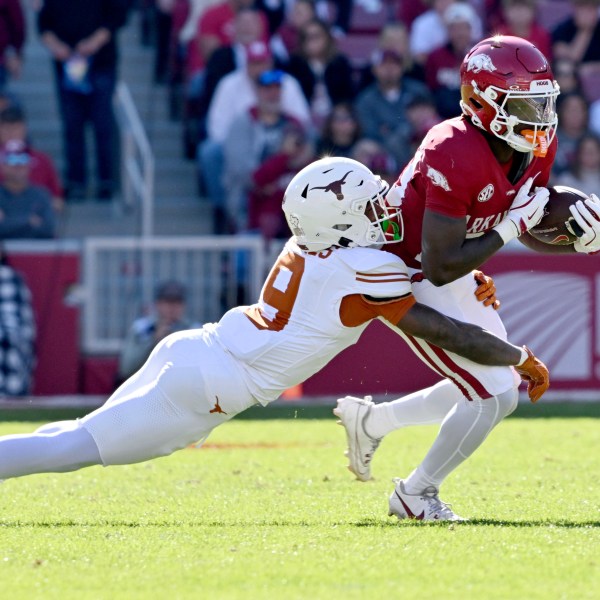 Arkansas running back Rodney Hill (20) is tackled by Texas defensive back Gavin Holmes (9) during the first half of an NCAA college football game Saturday, Nov. 16, 2024, in Fayetteville, Ark. (AP Photo/Michael Woods)