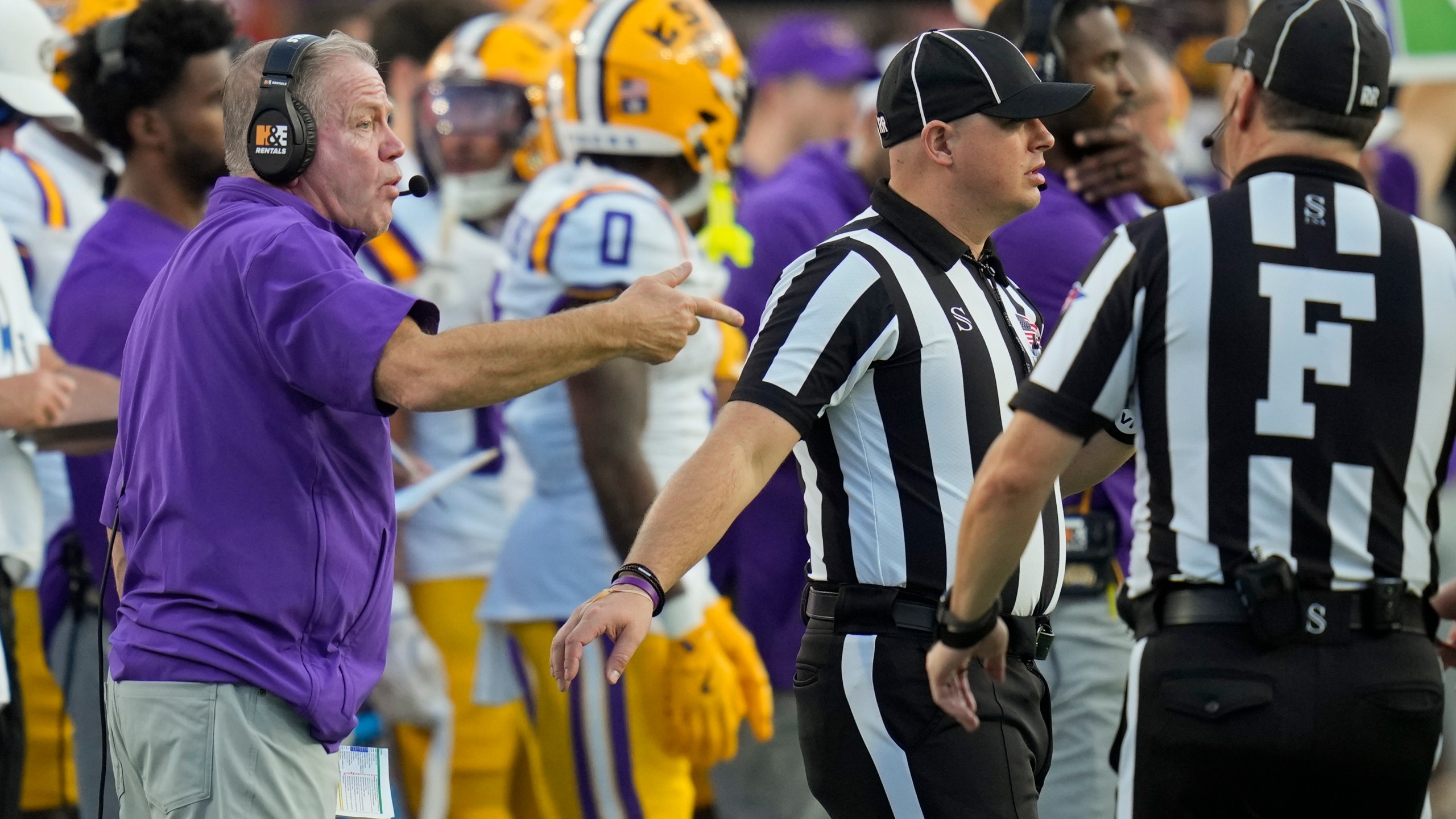 LSU head coach Brian Kelly, left, makes a point with officials during the first half of an NCAA college football game against Florida, Saturday, Nov. 16, 2024, in Gainesville, Fla. (AP Photo/John Raoux)