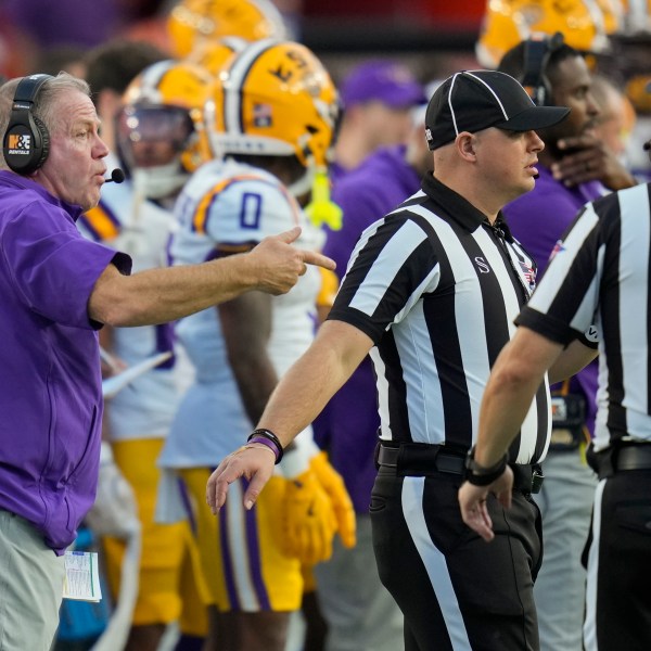 LSU head coach Brian Kelly, left, makes a point with officials during the first half of an NCAA college football game against Florida, Saturday, Nov. 16, 2024, in Gainesville, Fla. (AP Photo/John Raoux)