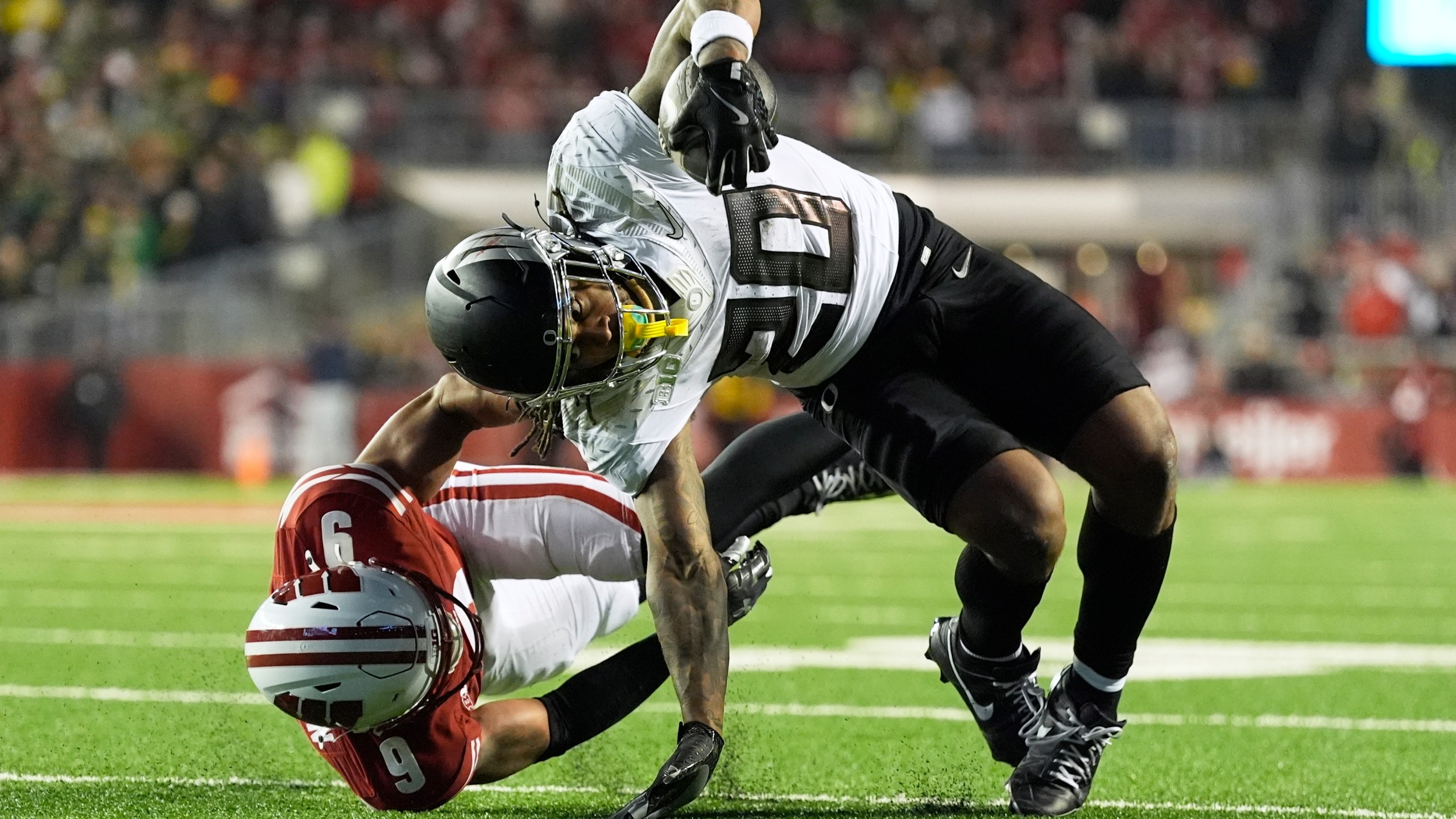 Wisconsin's Austin Brown (9) stops Oregon's Jordan James (20) during the second half of an NCAA college football game Saturday, Nov. 16, 2024, in Madison, Wis. Oregon won 16-13. (AP Photo/Morry Gash)